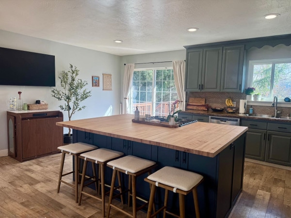 Open kitchen with a large butcher-block island and stools