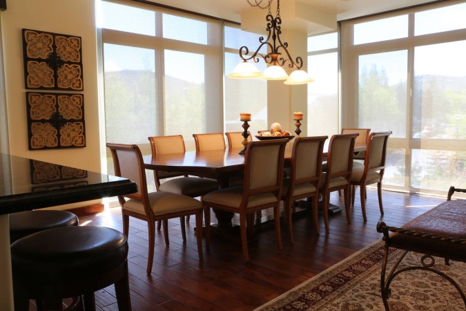 Large dining table beside floor-to-ceiling windows