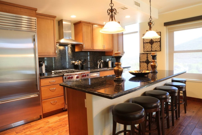 Full kitchen with a granite island and bar stools