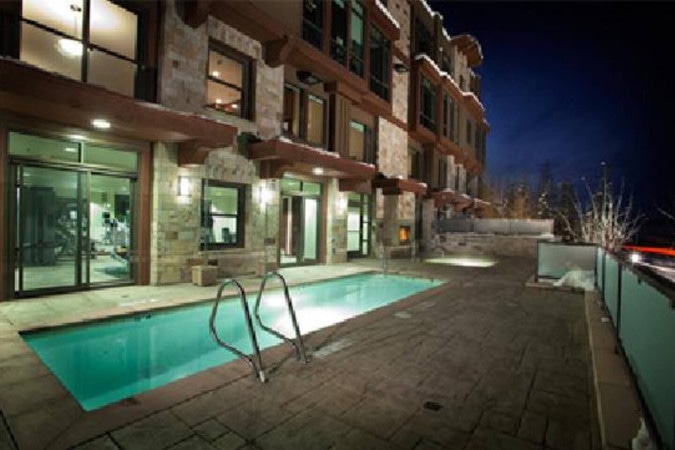 Heated outdoor pool beside the building at dusk