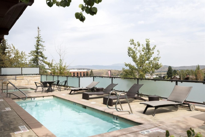 Outdoor pool and lounge chairs with the mountains beyond