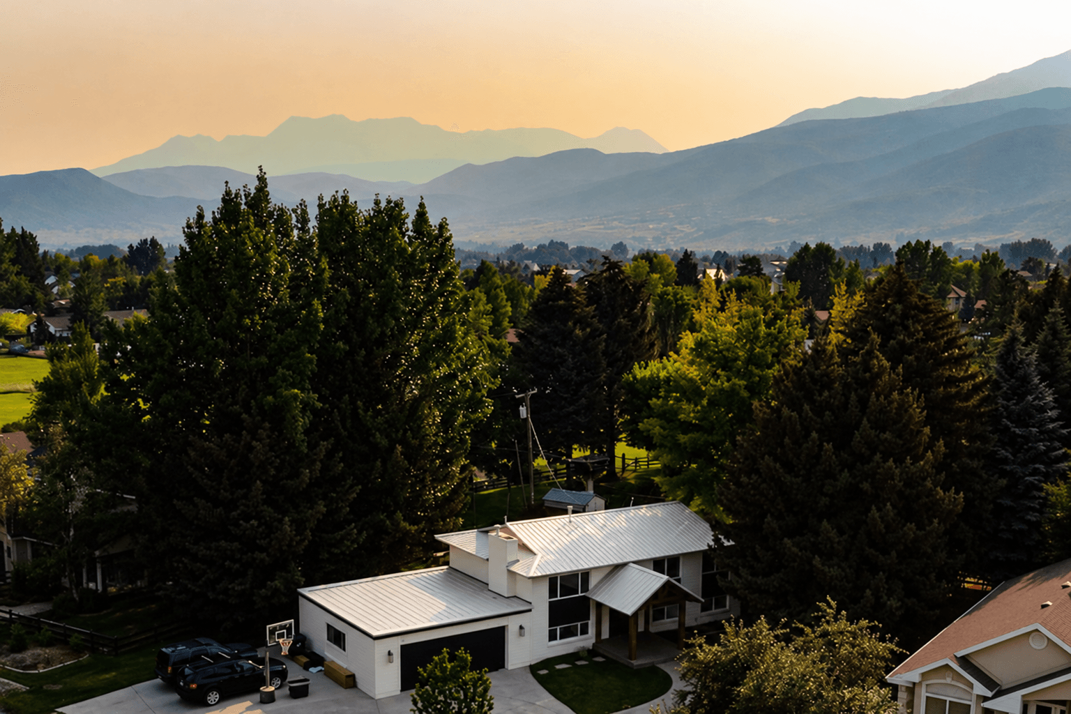 Hygge House among the trees in Midway with the mountains behind